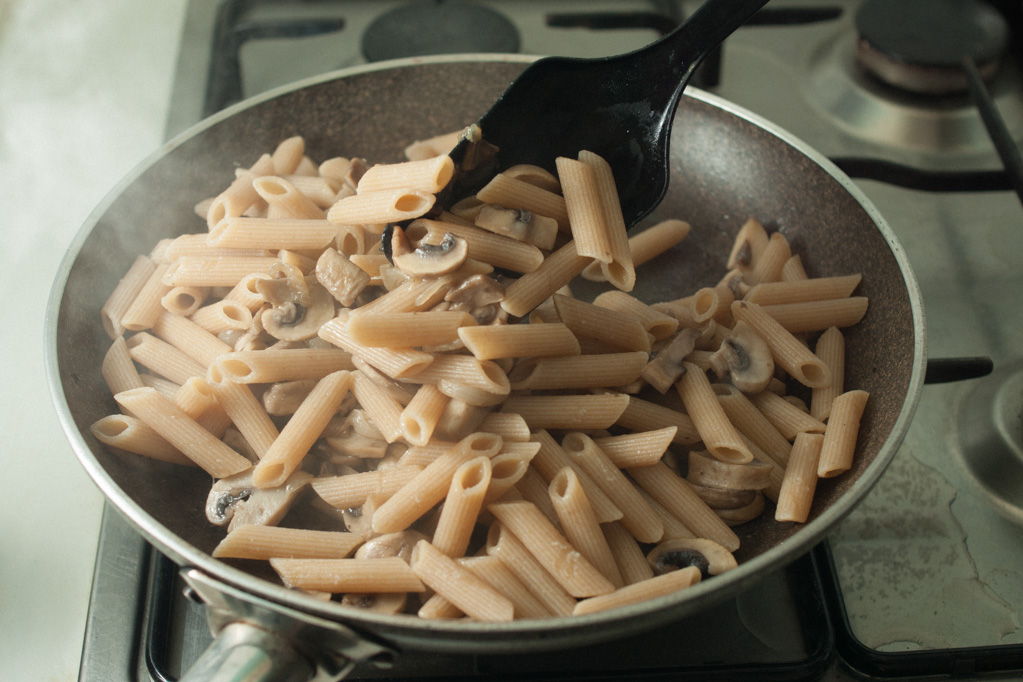 Penne al forno con funghi e crema di piselli - unire la pasta ai funghi