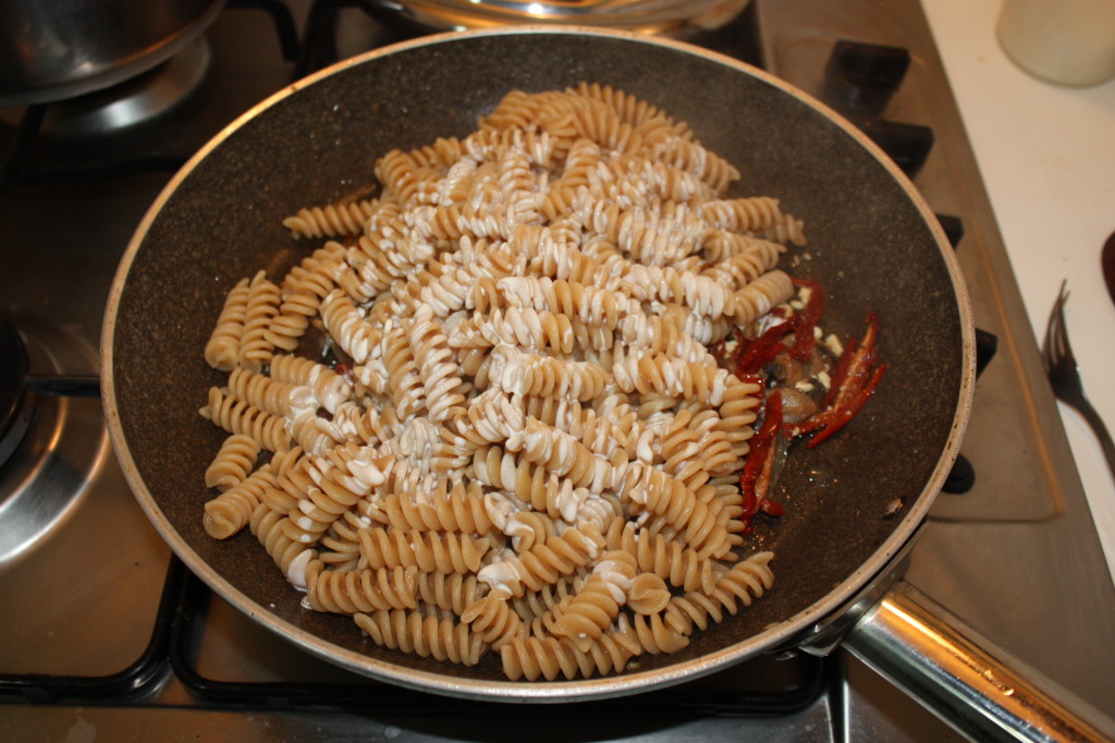 fusilli con funghi e pomodori secchi - unire la pasta al condimento